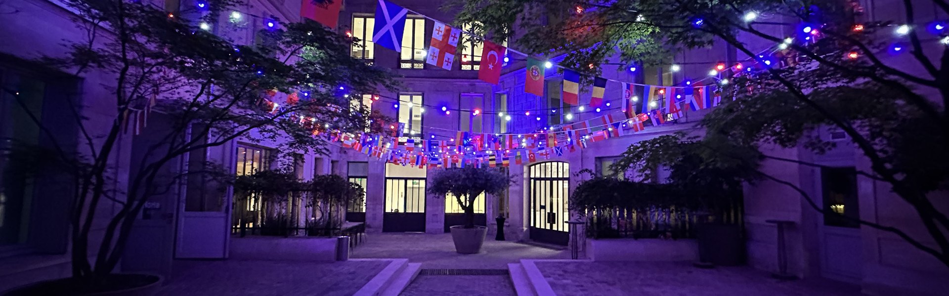 Guirlandes bleues, blanches et rouges pour un événement dans une cour